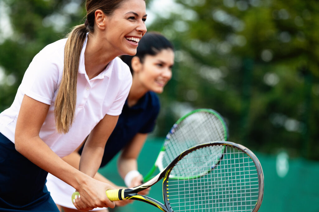 Fit happy poeple playing tennis together. Sport concept